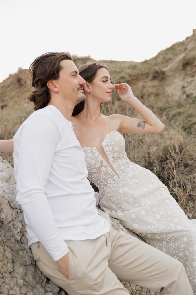 a young couple posing for their wedding photos in saskatchewan with colorful wedding flowers
