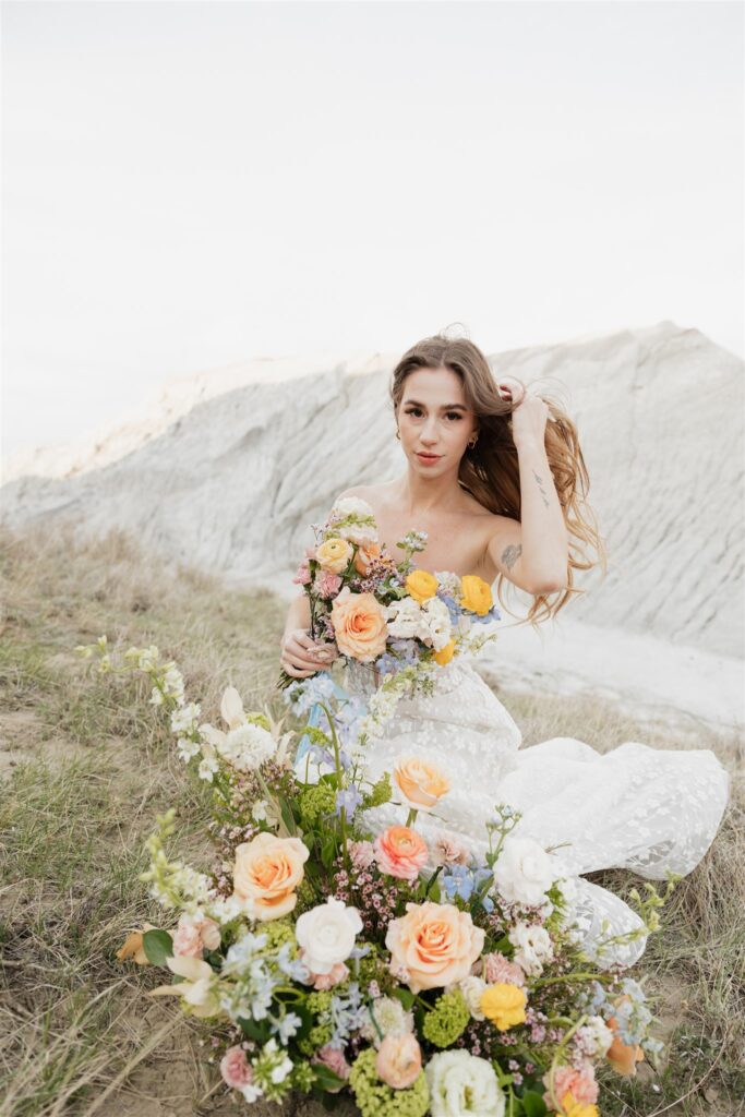 a young couple posing for their wedding photos in saskatchewan with colorful wedding flowers
