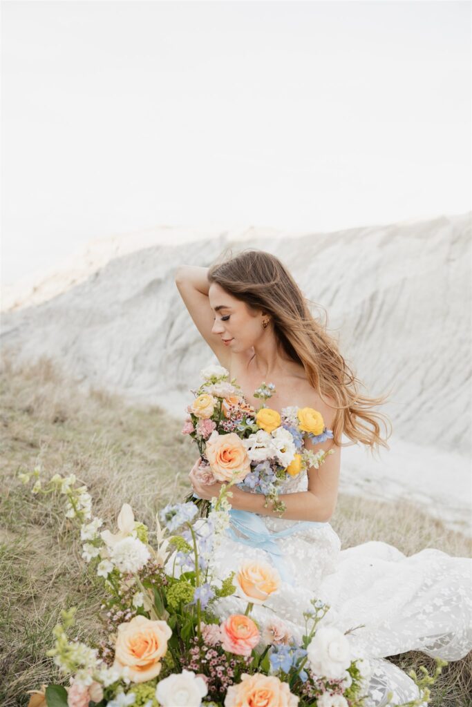 a young couple posing for their wedding photos in saskatchewan with colorful wedding flowers
