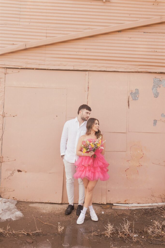 a couple playing and posing for a bright and vibrant photoshoot downtown