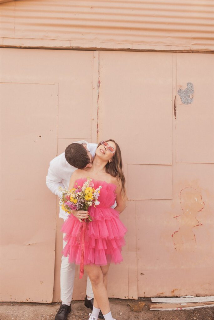 a couple playing and posing for a bright and vibrant photoshoot downtown