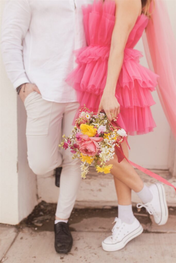 a couple playing and posing for a bright and vibrant photoshoot downtown