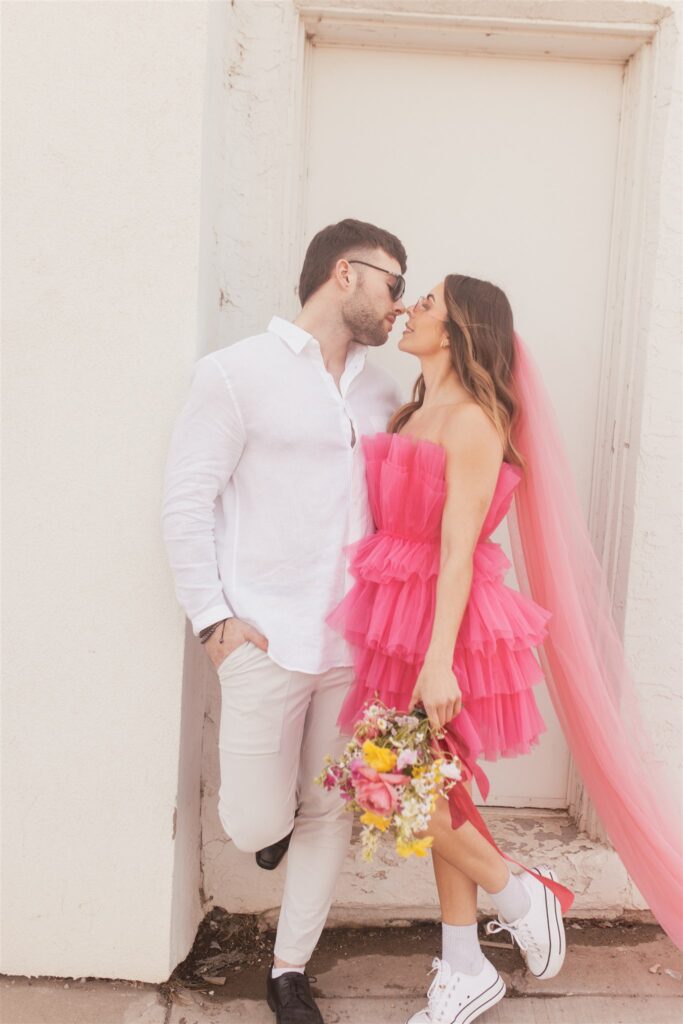 couple posing for their downtown saskatoon photoshoot in bright colored clothes
