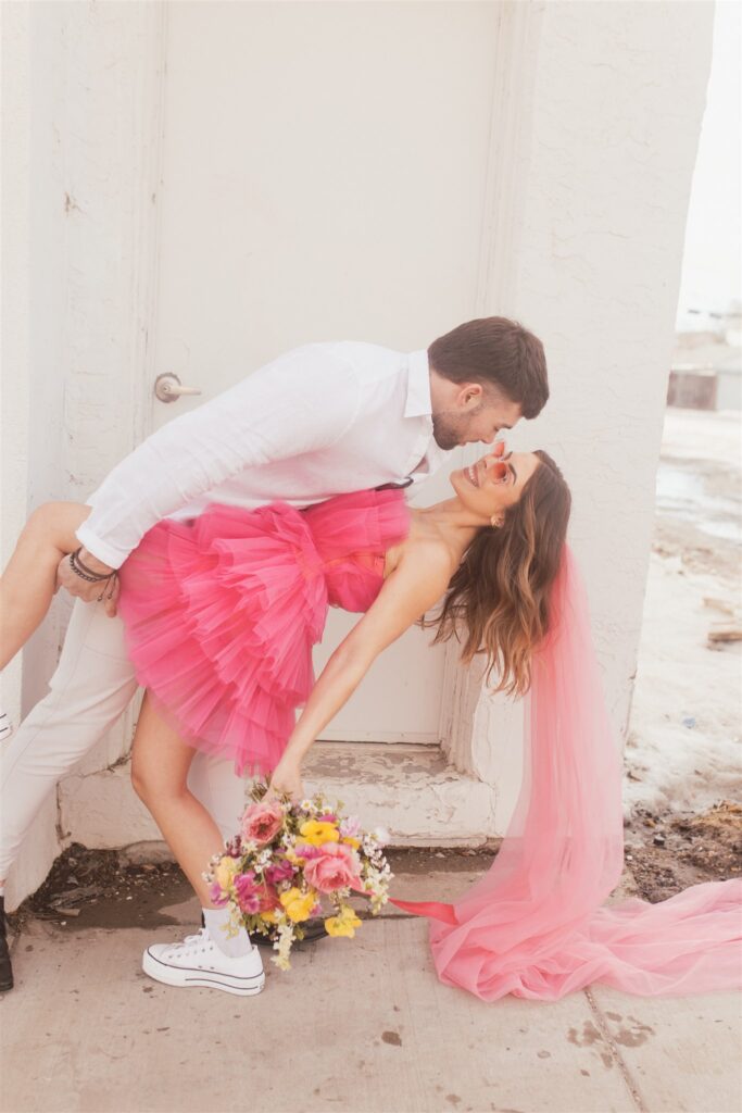 couple posing for their downtown saskatoon photoshoot in bright colored clothes
