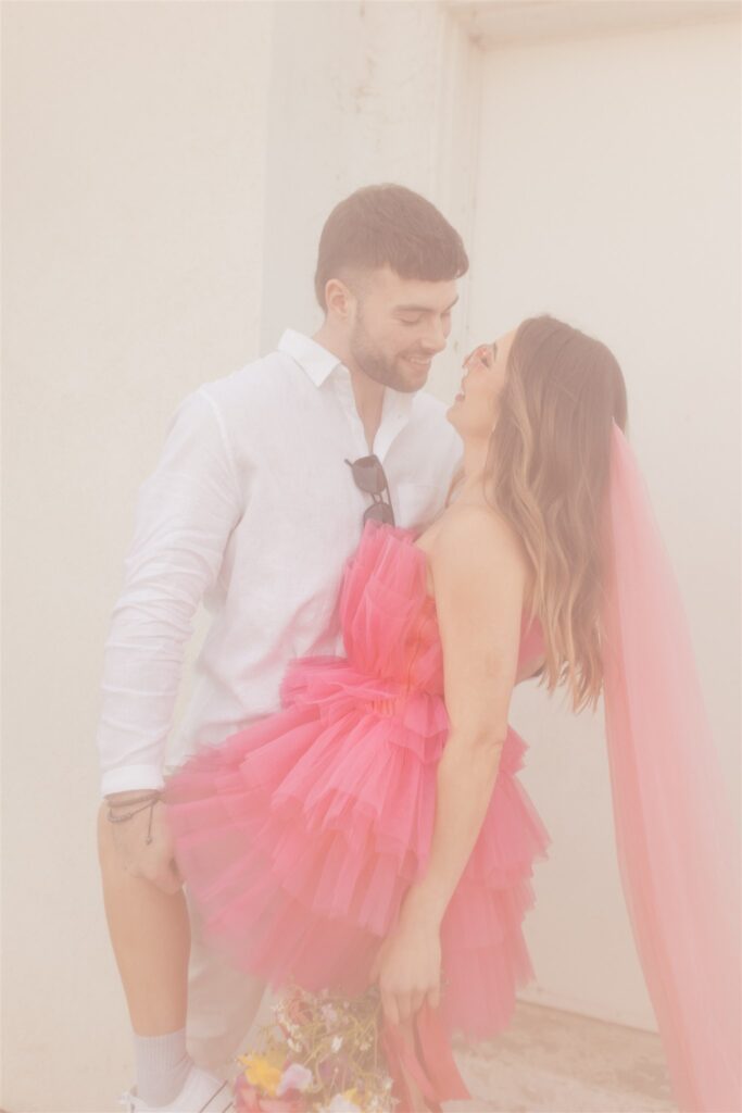 couple posing for their downtown saskatoon photoshoot in bright colored clothes
