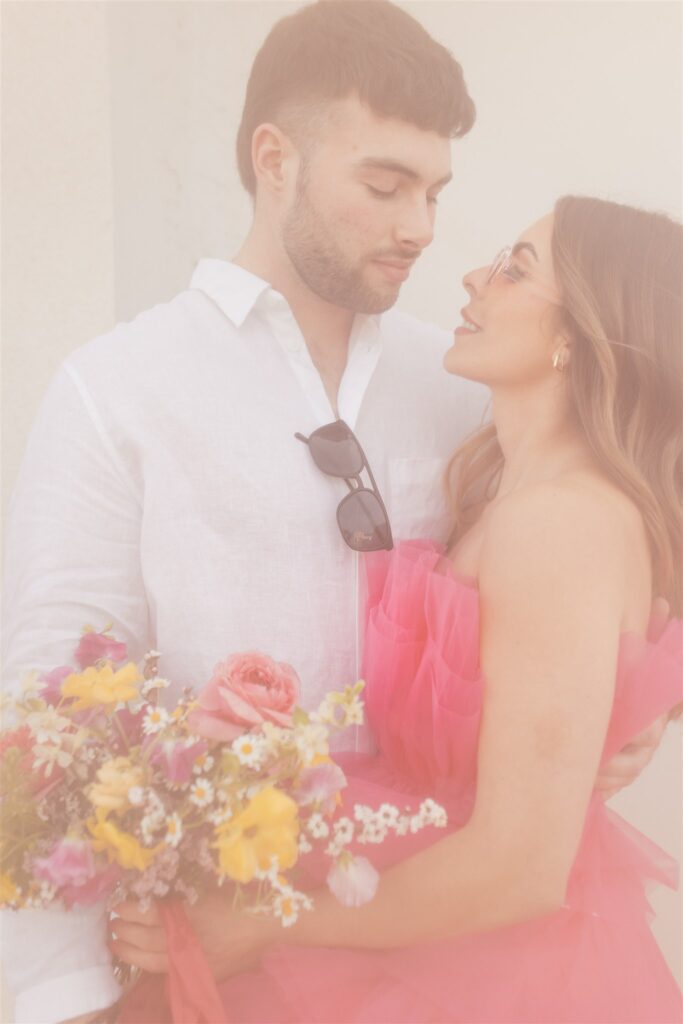 couple posing for their downtown saskatoon photoshoot in bright colored clothes
