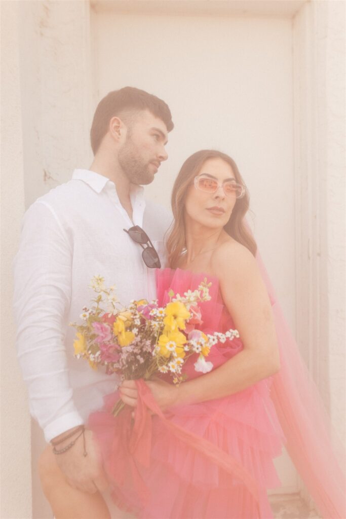 couple posing for their downtown saskatoon photoshoot in bright colored clothes
