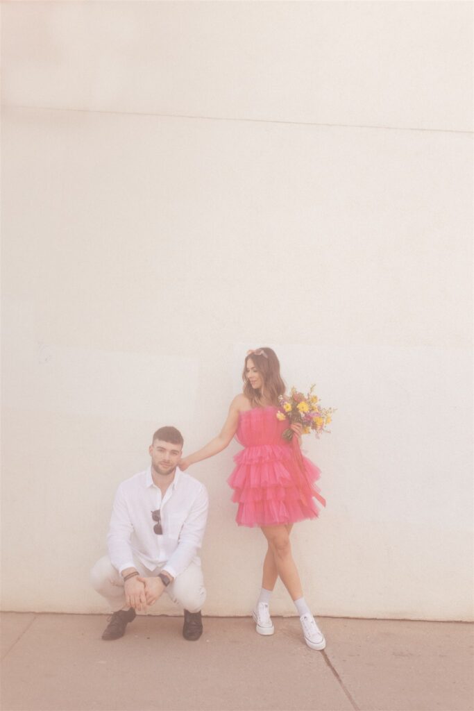 couple posing for their downtown saskatoon photoshoot in bright colored clothes
