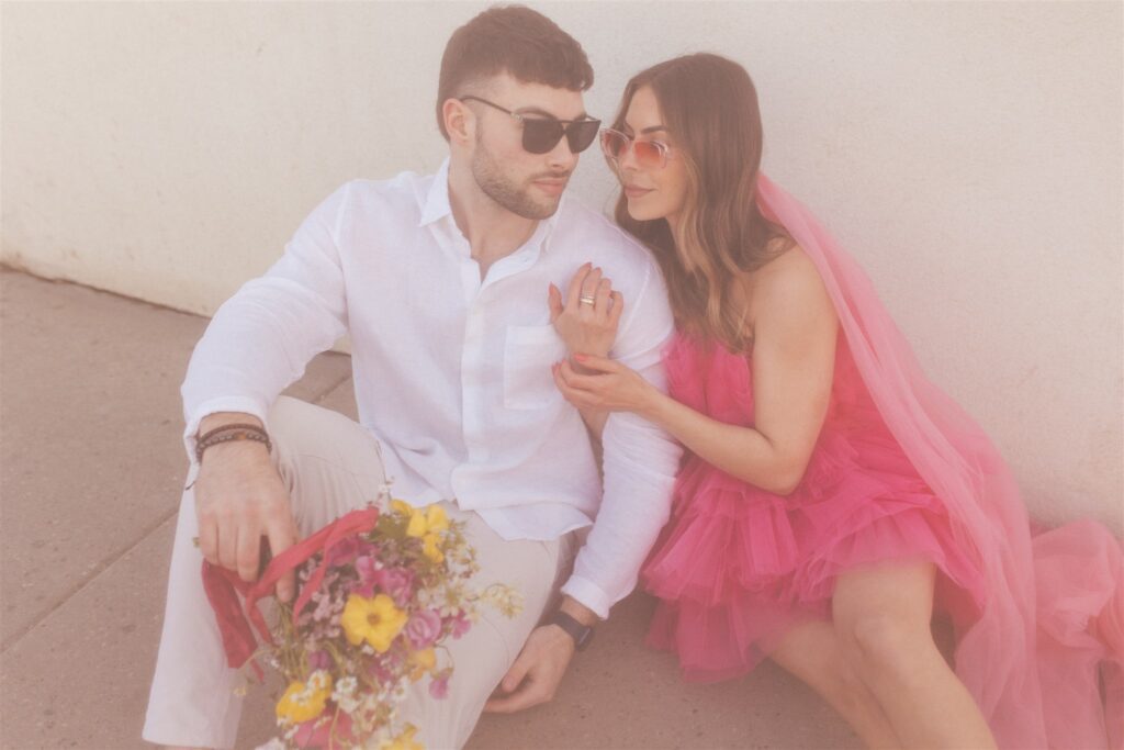 a couple playing and posing for a bright and vibrant photoshoot downtown