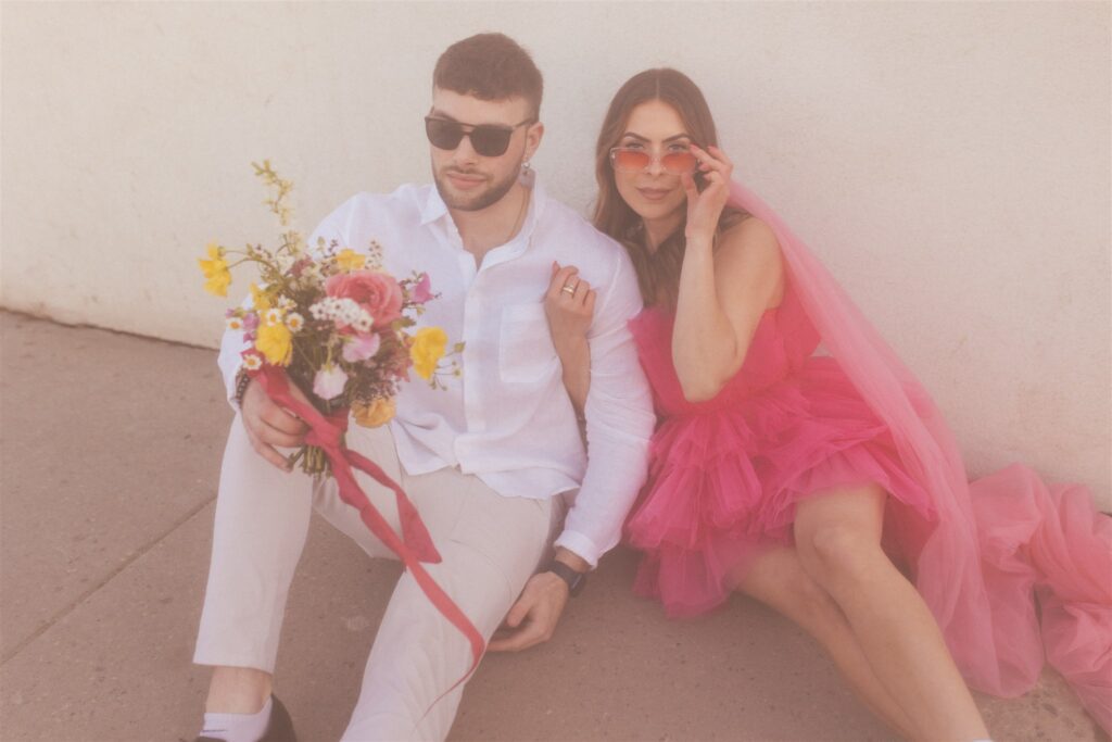 a couple playing and posing for a bright and vibrant photoshoot downtown