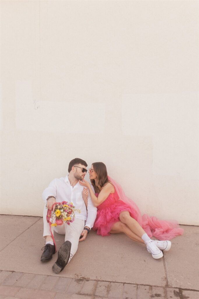 couple posing for their downtown saskatoon photoshoot in bright colored clothes
