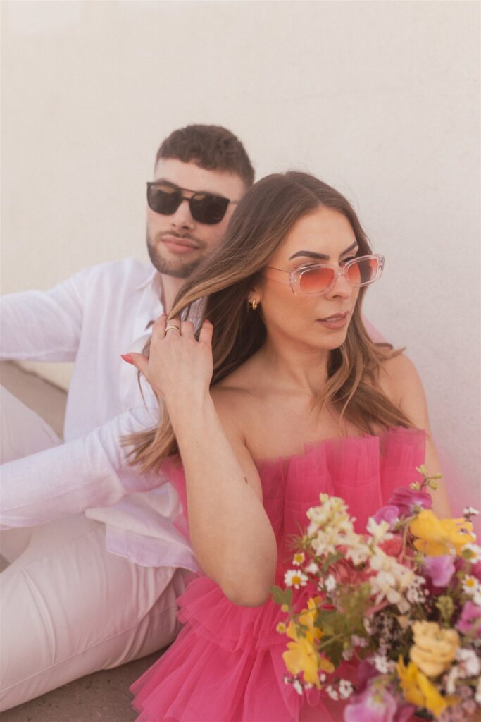 couple posing for their downtown saskatoon photoshoot in bright colored clothes
