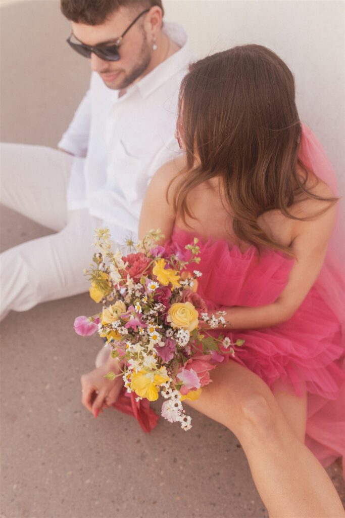 couple posing for their downtown saskatoon photoshoot in bright colored clothes
