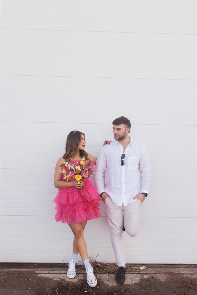 a couple playing and posing for a bright and vibrant photoshoot downtown