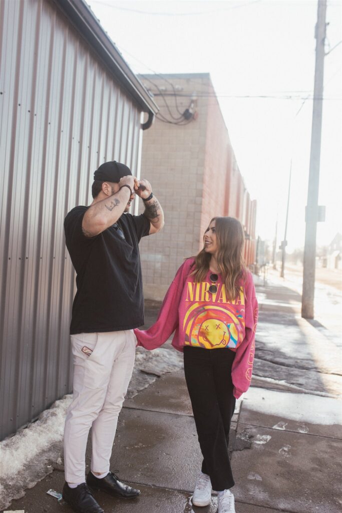 a couple playing and posing for a bright and vibrant photoshoot downtown