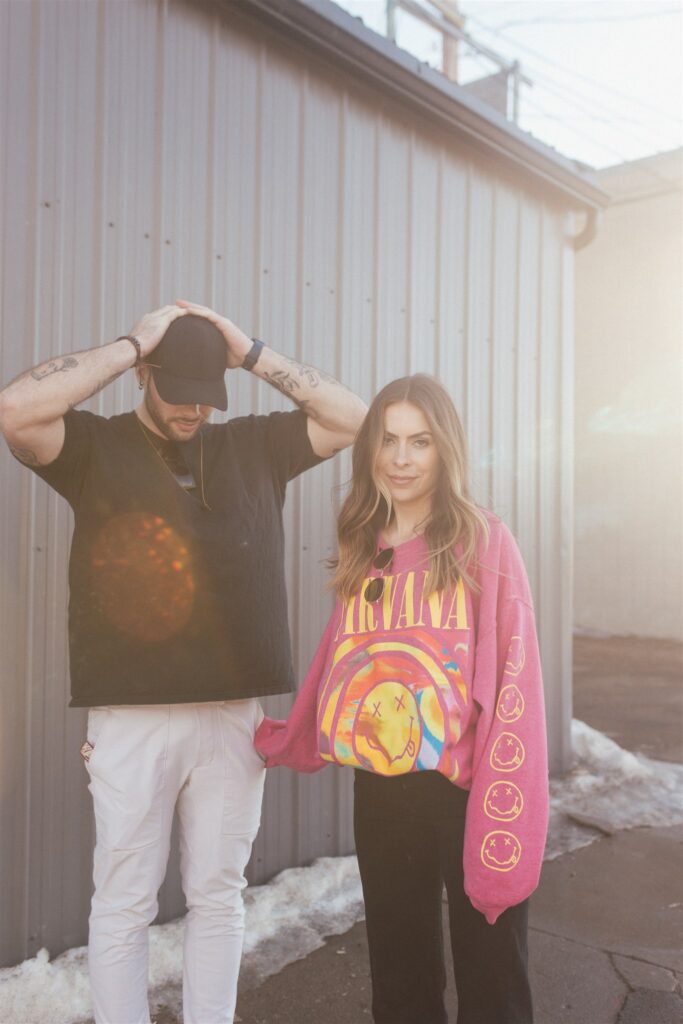 couple posing for their downtown saskatoon photoshoot in bright colored clothes
