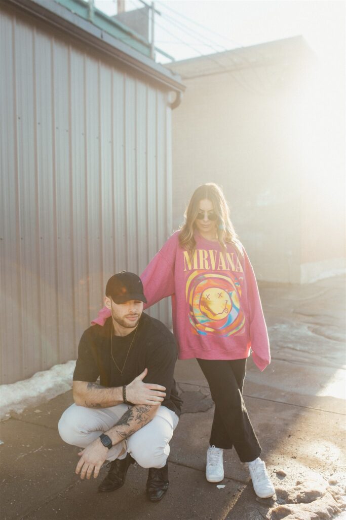 couple posing for their downtown saskatoon photoshoot in bright colored clothes
