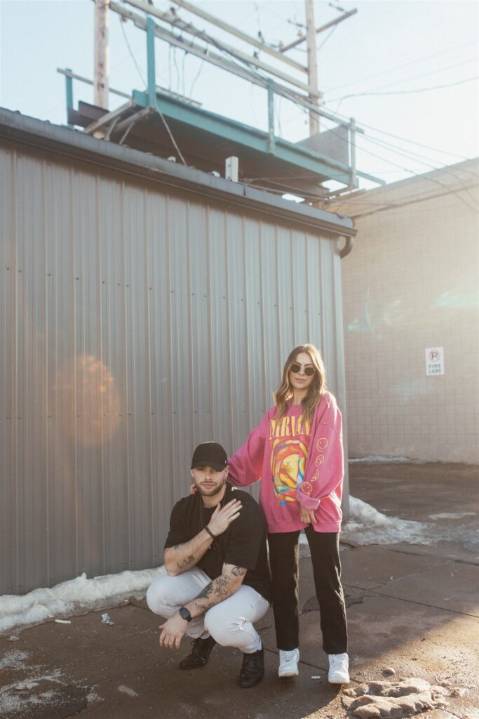 couple posing for their downtown saskatoon photoshoot in bright colored clothes
