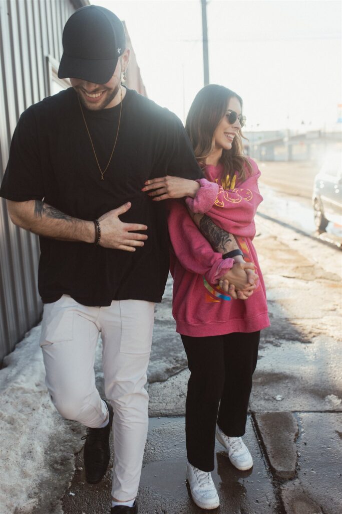 couple posing for their downtown saskatoon photoshoot in bright colored clothes
