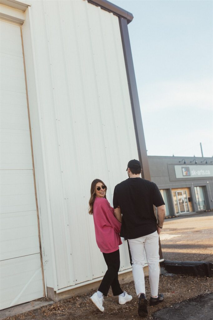 couple posing for their downtown saskatoon photoshoot in bright colored clothes
