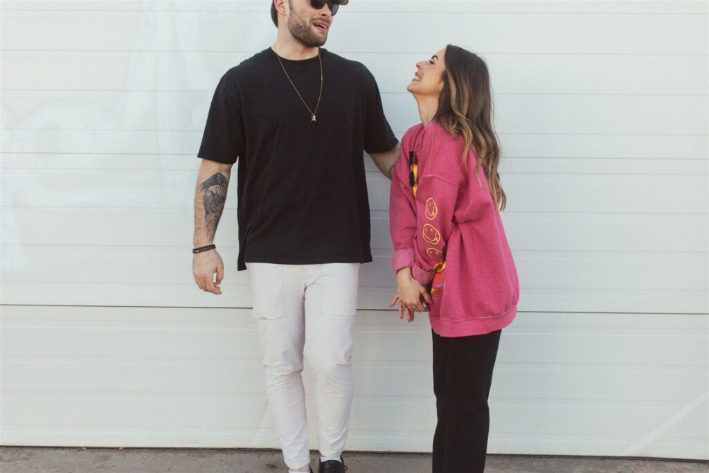 couple posing for their downtown saskatoon photoshoot in bright colored clothes
