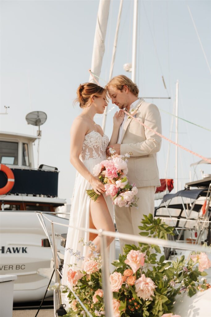 a couple posing with colorful flower on a boat for elopement pictures
