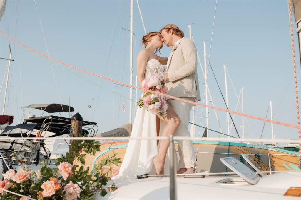 a couple posing with colorful flower on a boat for elopement pictures
