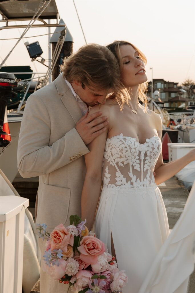 Couple posing on a boat for their colorful elopement in british columbia - sailboat elopement
