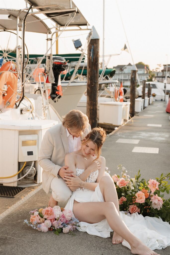 Couple posing on a boat for their colorful elopement in british columbia - sailboat elopement
