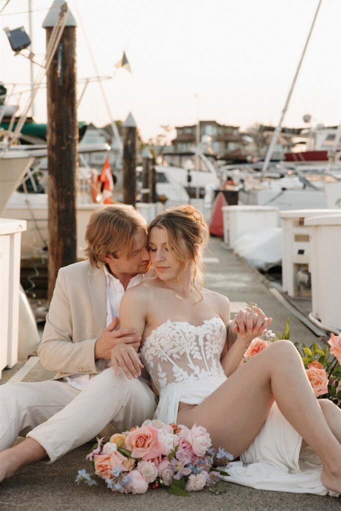 Couple posing on a boat for their colorful elopement in british columbia - sailboat elopement
