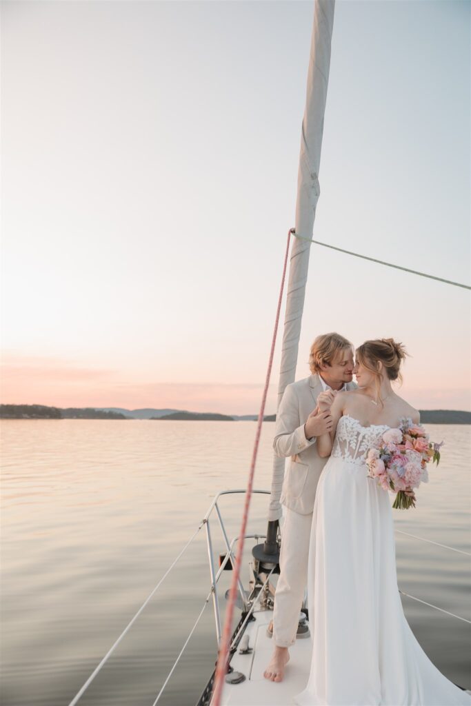 a couple posing with colorful flower on a boat for elopement pictures
