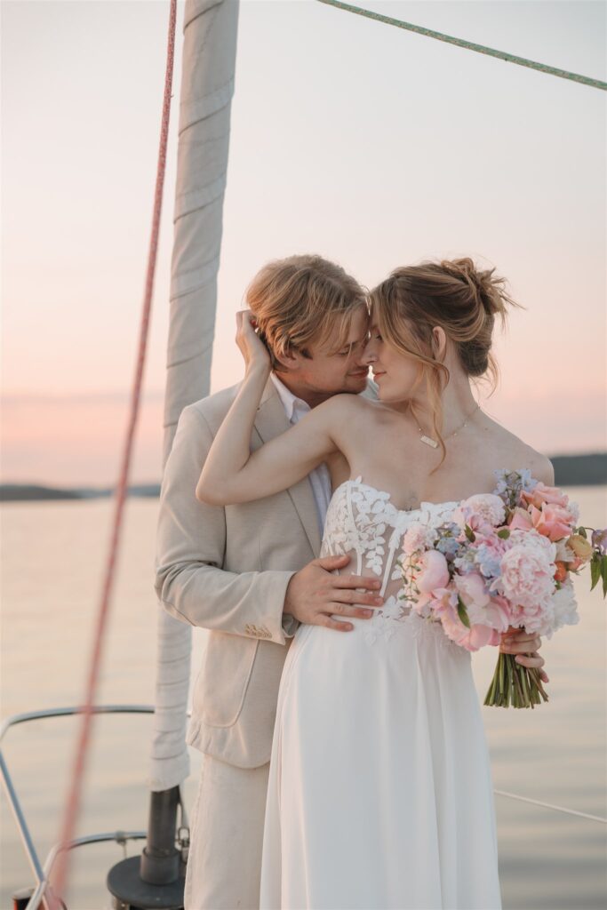 a couple posing with colorful flower on a boat for elopement pictures
