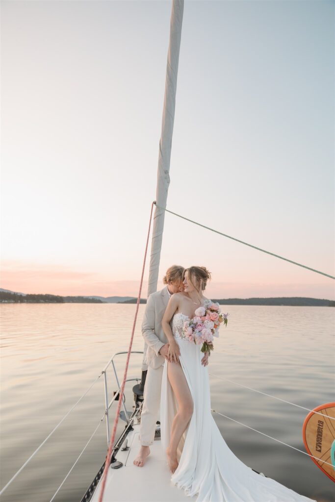 Couple posing on a boat for their colorful elopement in british columbia - sailboat elopement
