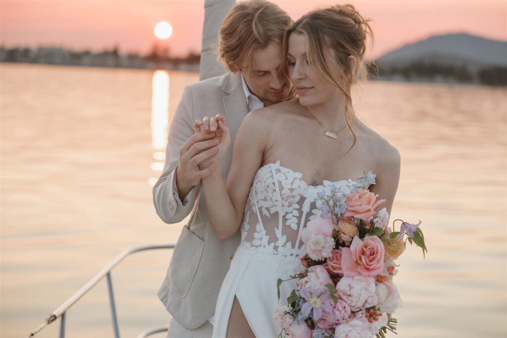 Couple posing on a boat for their colorful elopement in british columbia - sailboat elopement
