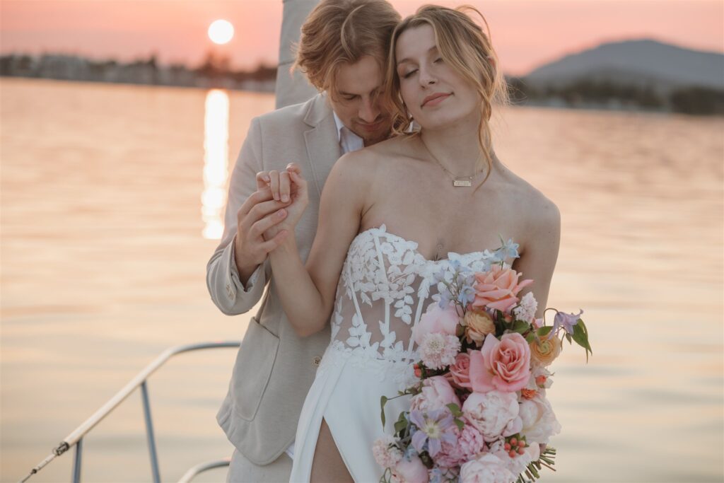 Couple posing on a boat for their colorful elopement in british columbia - sailboat elopement
