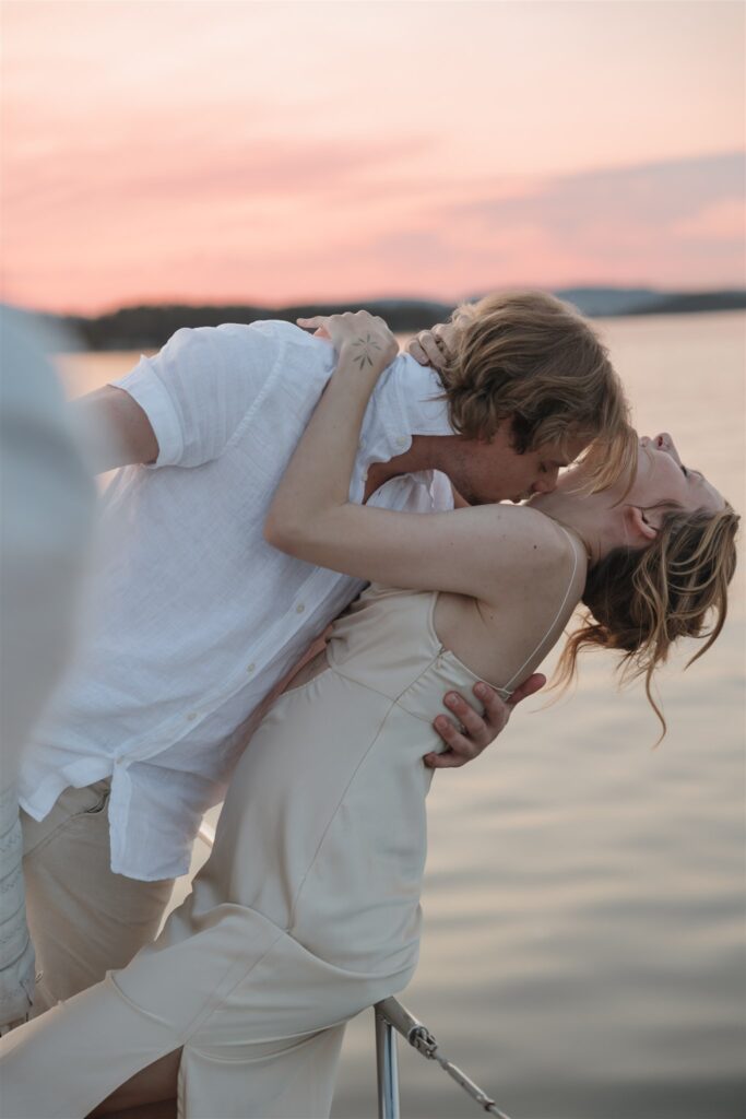 Couple posing on a boat for their colorful elopement in british columbia - sailboat elopement