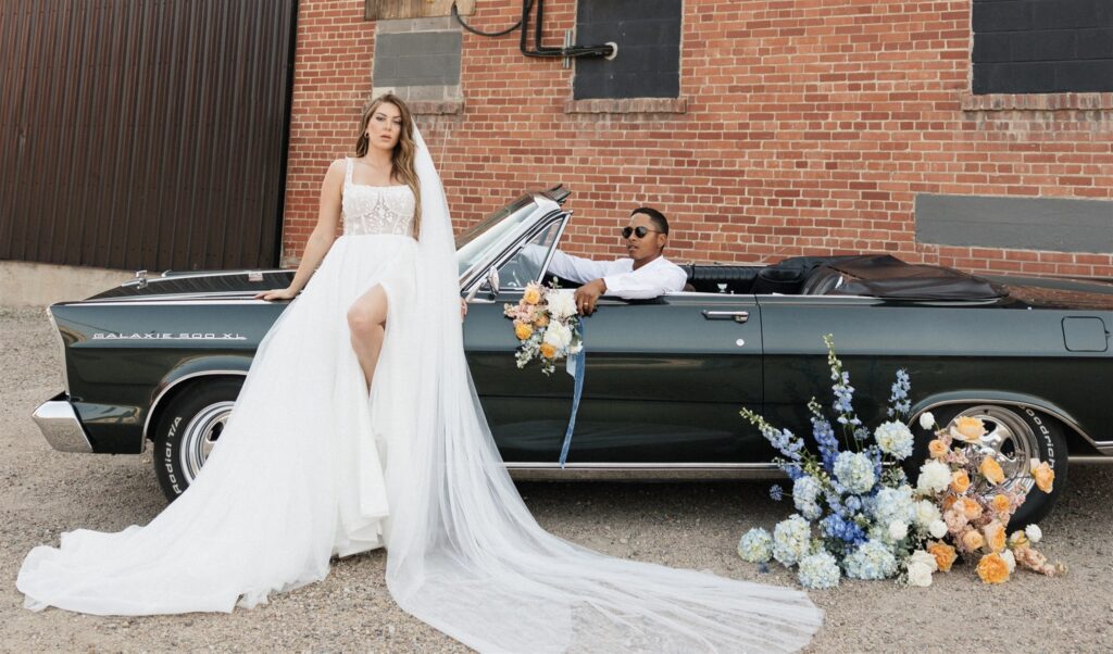 couple posing with a vintage car for their editorial wedding photos
