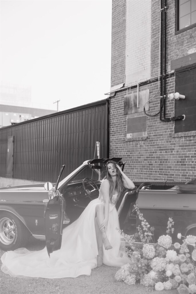 couple posing with a vintage car for their urban wedding photos | Modern Editorial Wedding Photos in Downtown Saskatoon
