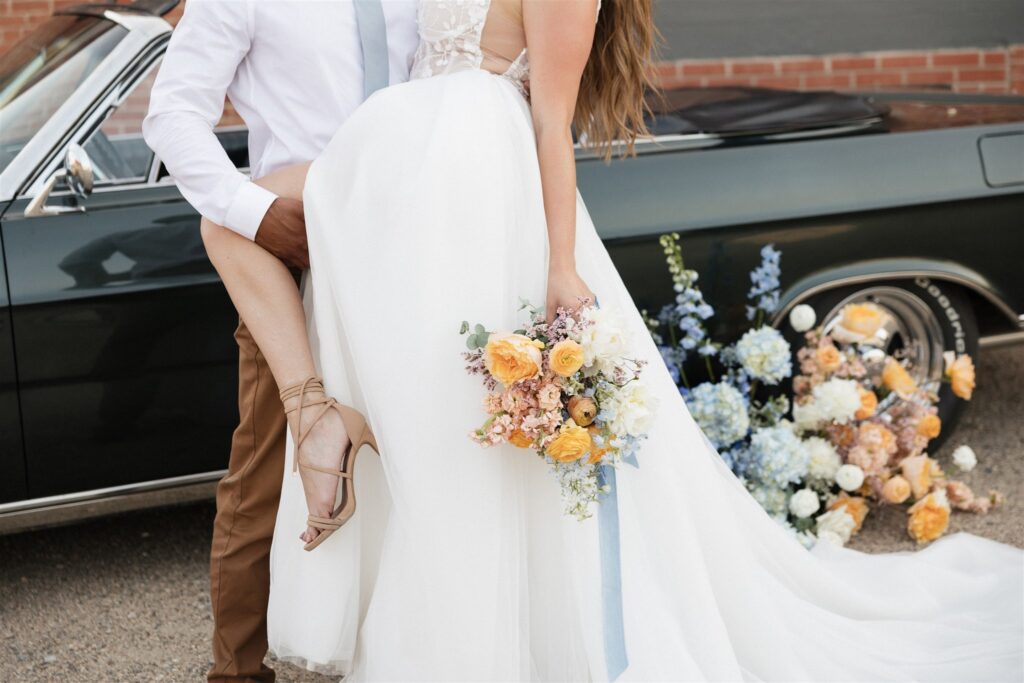 couple posing with a vintage car for their urban wedding photos | Modern Editorial Wedding Photos in Downtown Saskatoon
