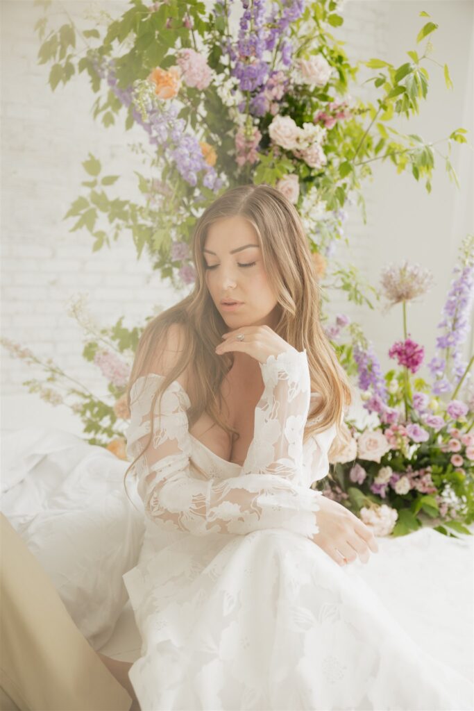 bride and groom posing in a white studio with bright wedding flowers and bouquet
