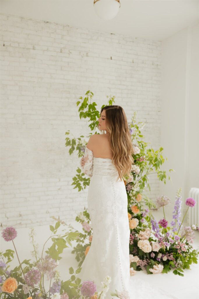 bride and groom posing in a white studio with bright wedding flowers and bouquet
