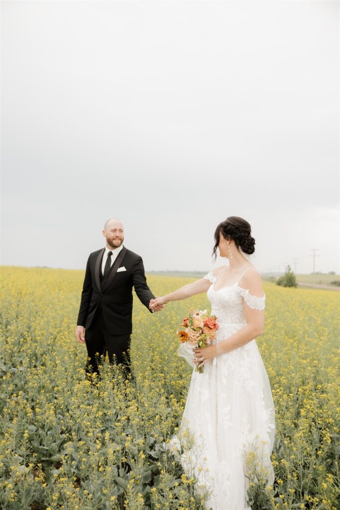 luxurious wedding photography of bride and groom posing in a field in saskatoon