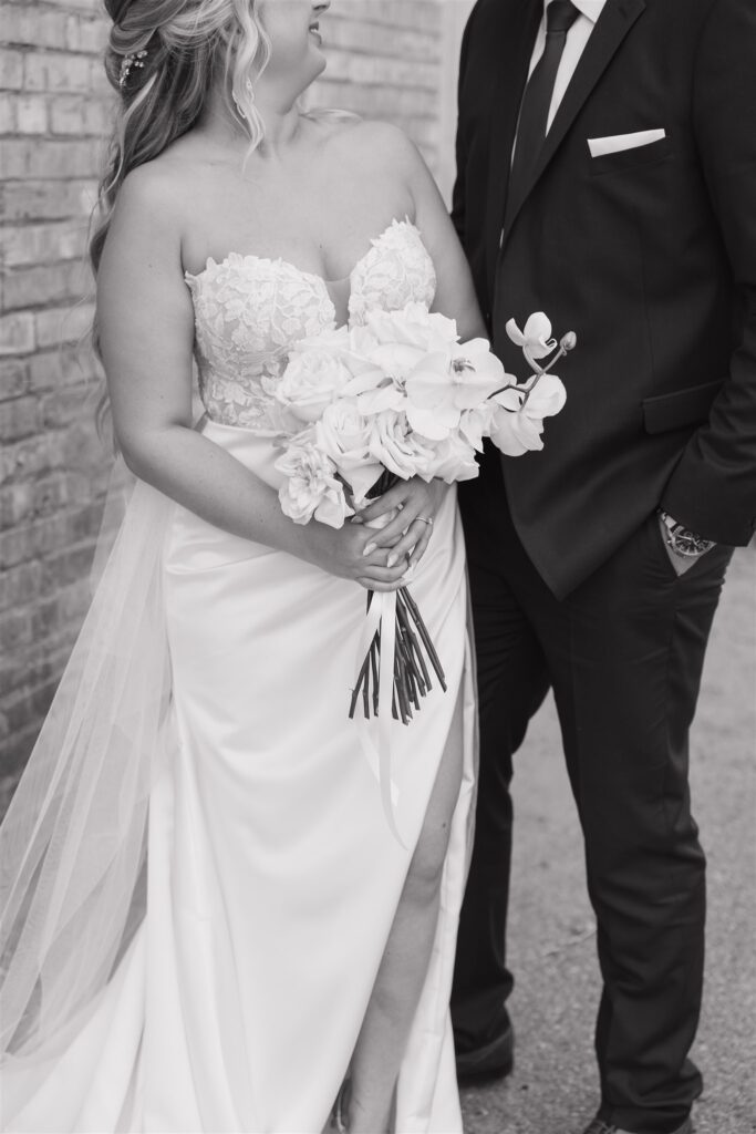 bride and groom posing in a field in canada for their wedding portraits
