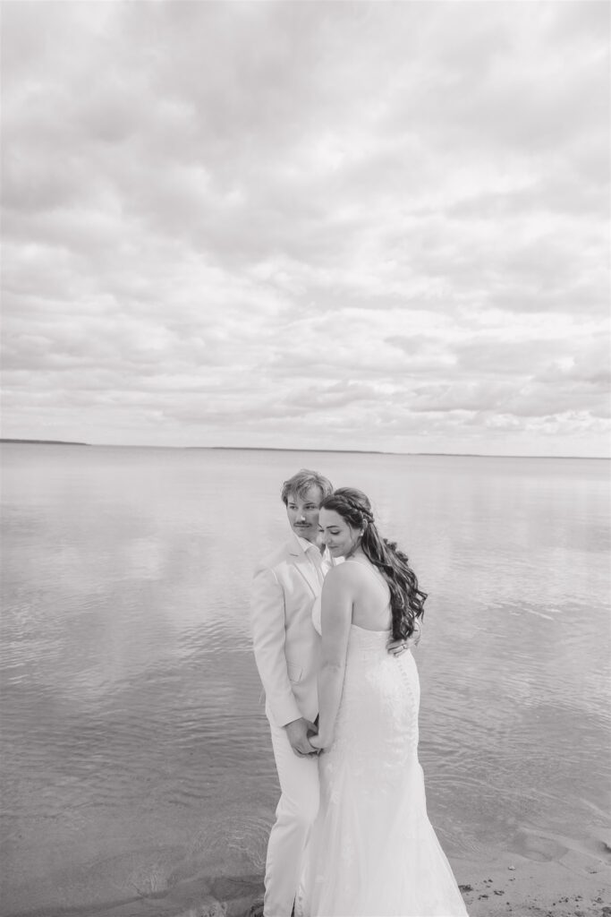 couple posing on a lake for their wedding photos
