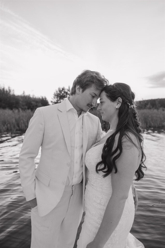 couple posing on a lake for their wedding photos
