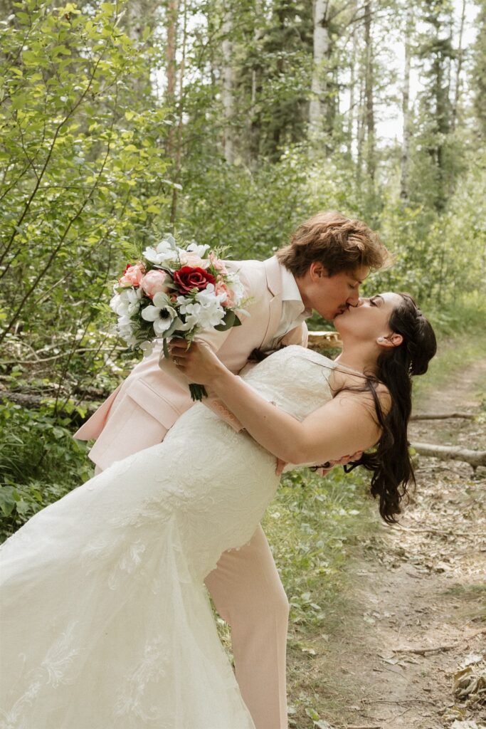 bride and groom posing for their wedding photos in a forest