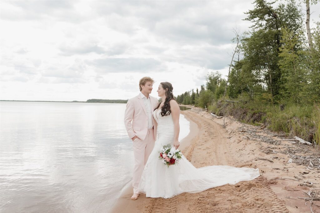 couple posing on a lake for their wedding photos
