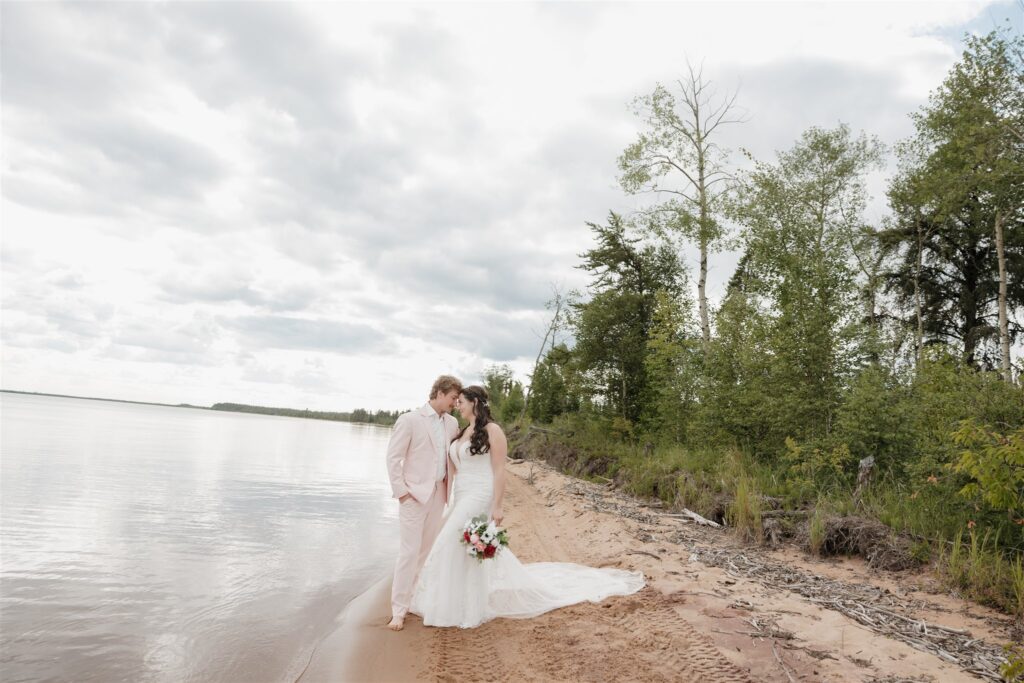 couple posing on a lake for their wedding photos
