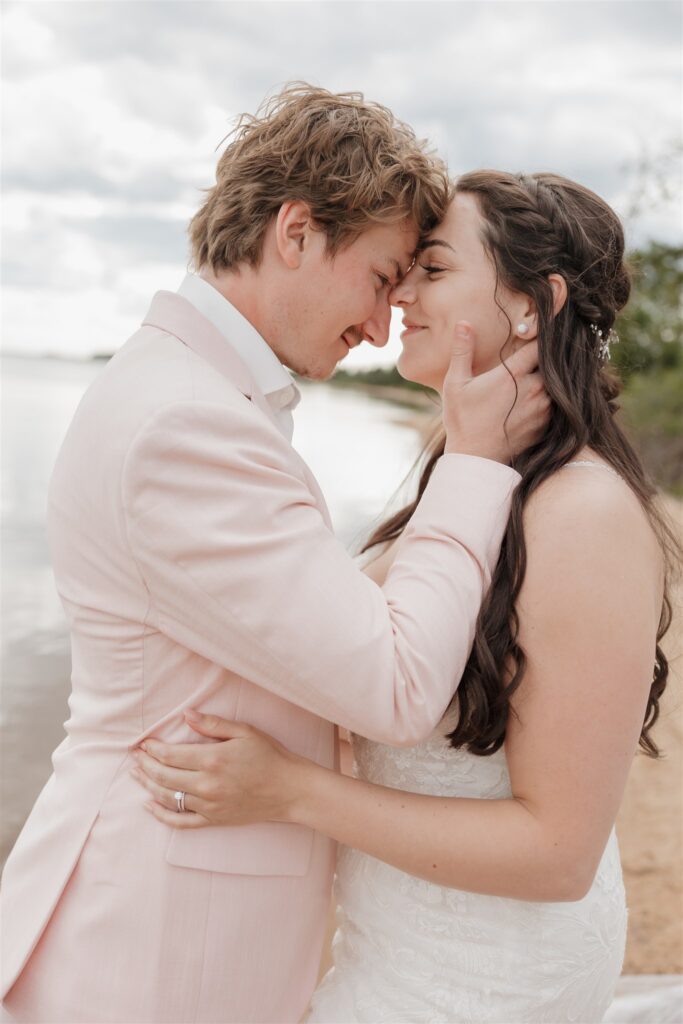 couple posing on a lake for their wedding photos
