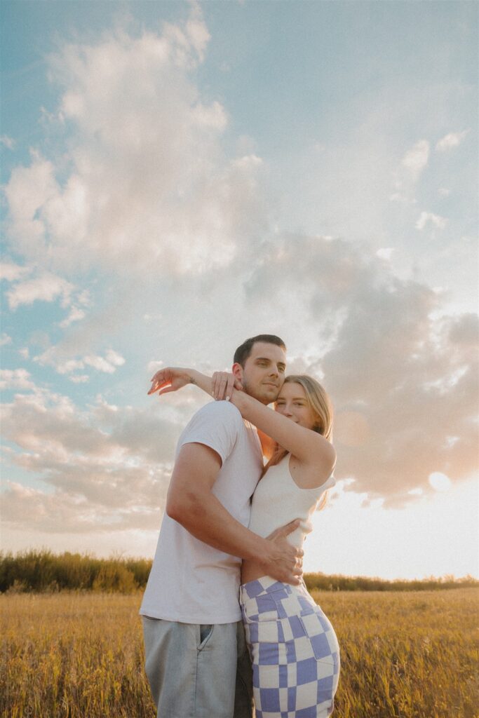 couples posing in a field in canada